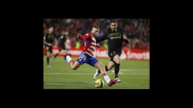 Cầu thủ của Tenerife vượt qua cầu thủ của Granada trong trận đấu bóng đá.